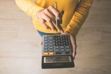 Woman,Entrepreneur,Using,A,Calculator,With,A,Pen,In,Her
